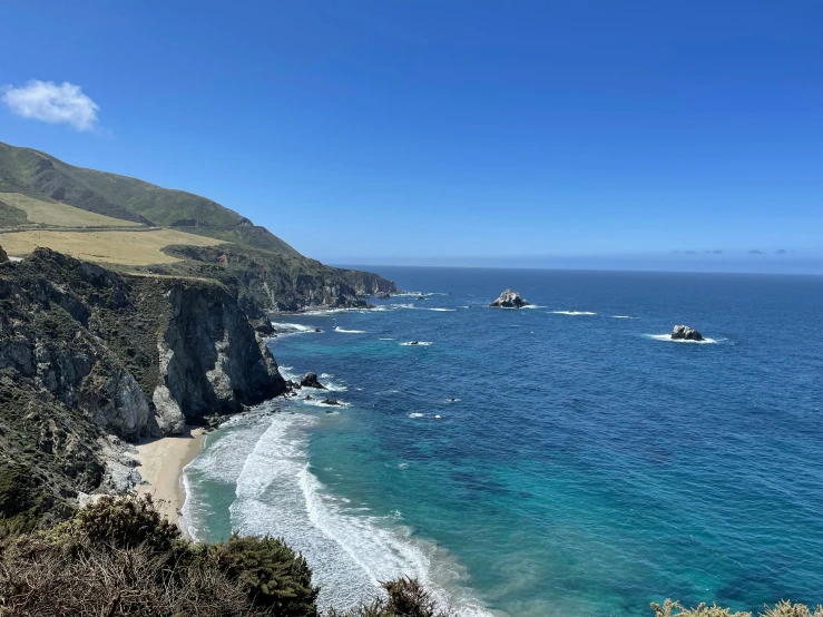 the coast line is next to the mountains and the blue water