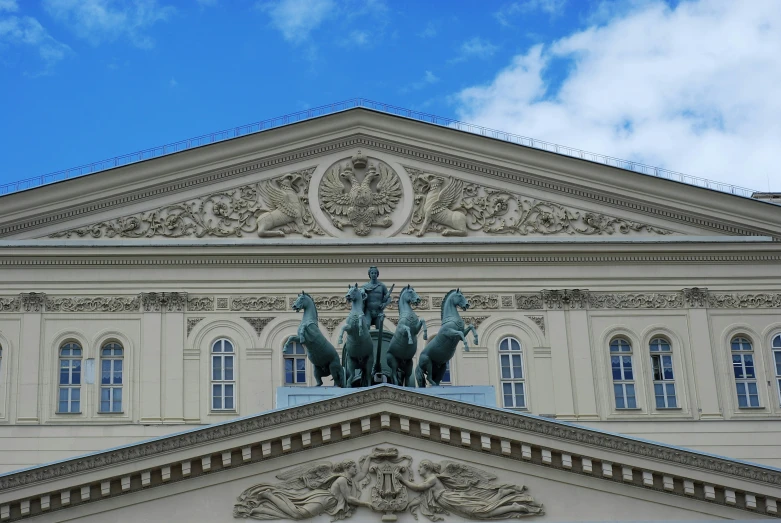 a large white building has statues and arches above