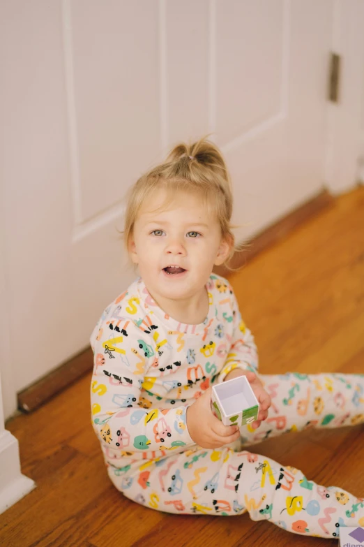 a small girl is sitting on the floor