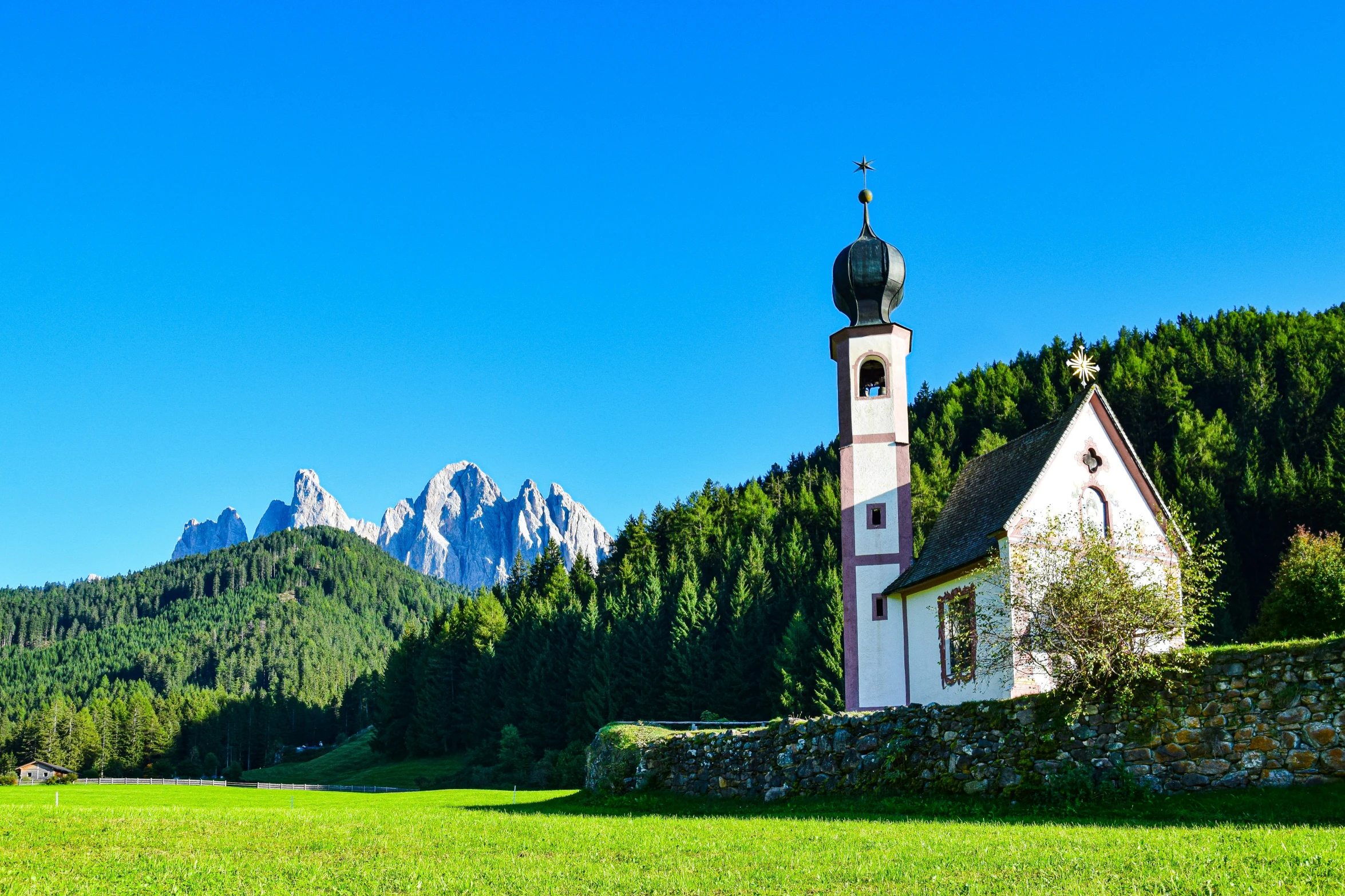 the building with the bell on top is in the middle of the mountain