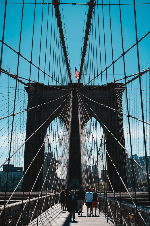 people walking across the brooklyn bridge together