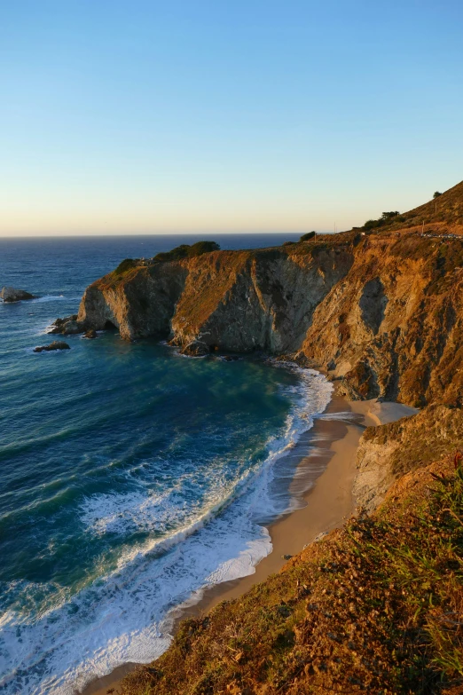 there is a sandy coast next to the ocean