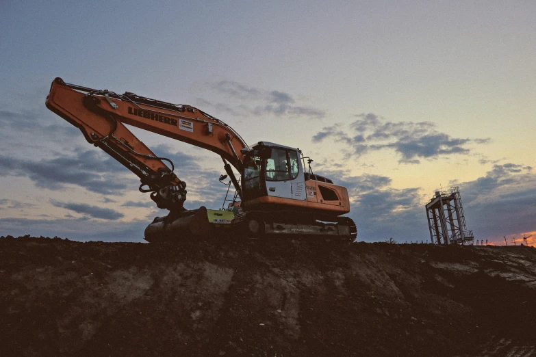 an orange excavator machine sitting in the dirt