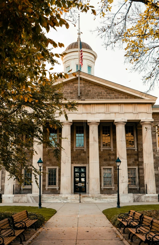 a building with pillars and several benches on it