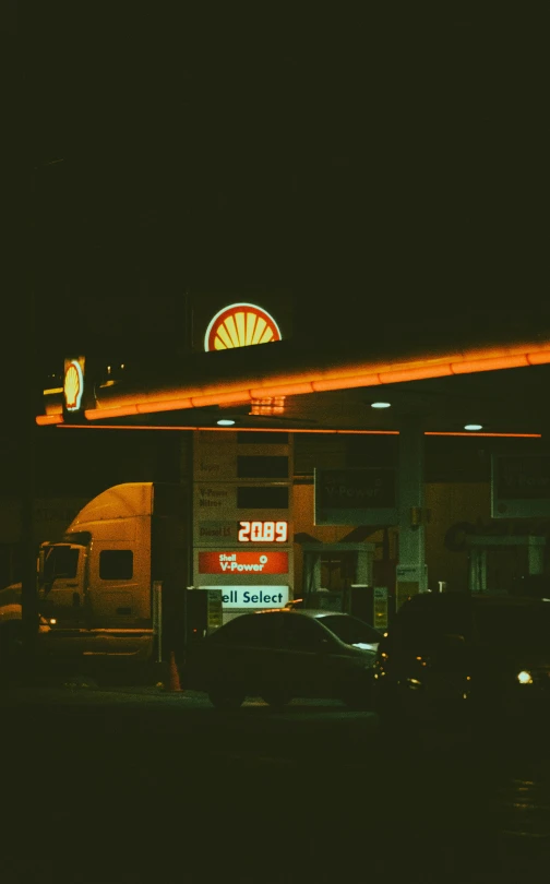 a gas station with a lit up sign at night