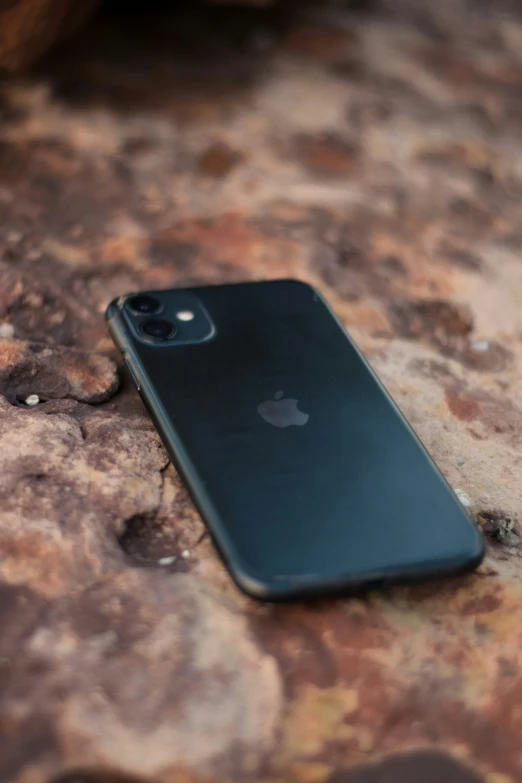 an iphone on a rock surface that appears to be made out of black plastic