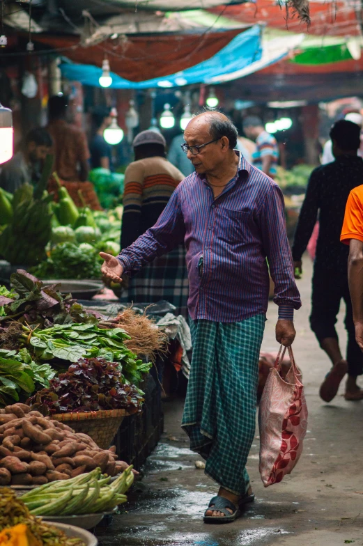 a man wearing glasses is walking through the market