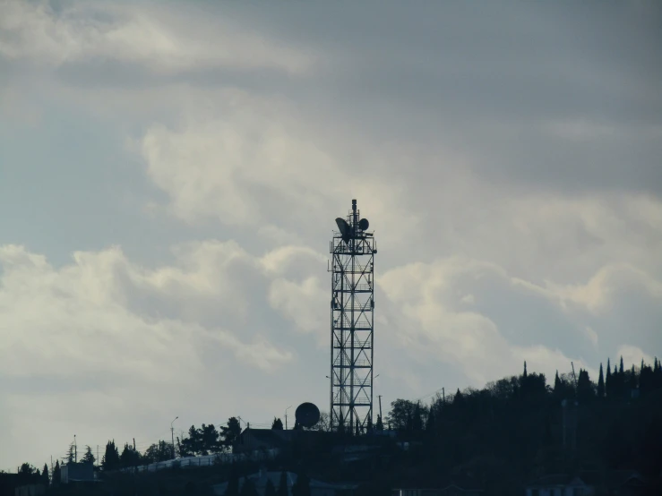 a large metal tower near the water in the background