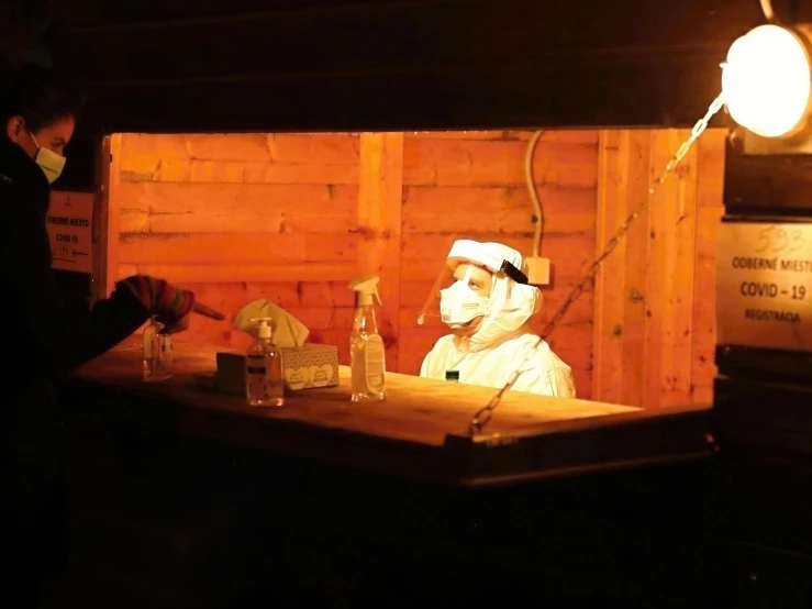 a couple in white coats and hats sitting at a bar