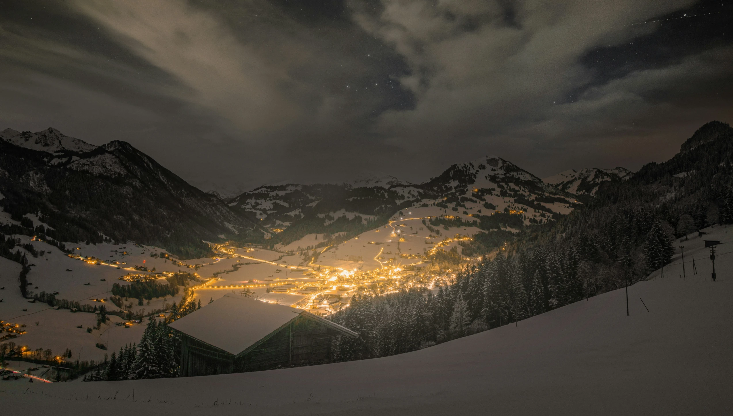 snow covered mountains are lit up by lights at night