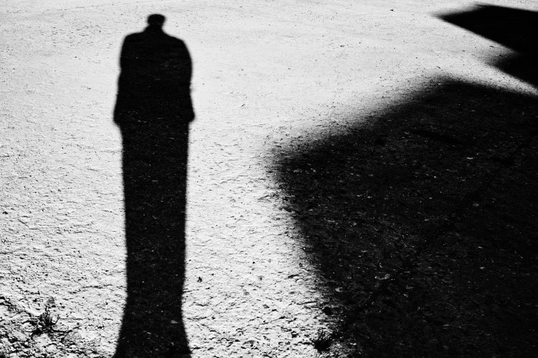 the shadow of a man is cast on the ground