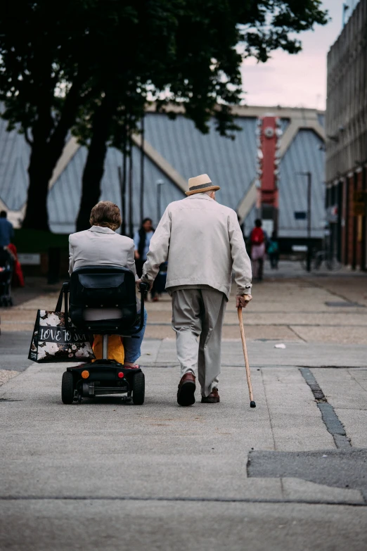 the older man is hing a walker with his companion