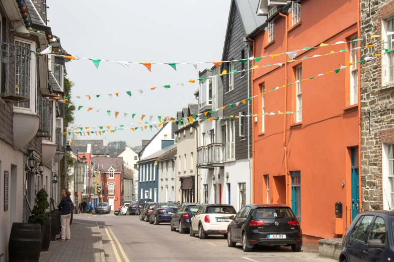 cars parked along a street with bunting streamers