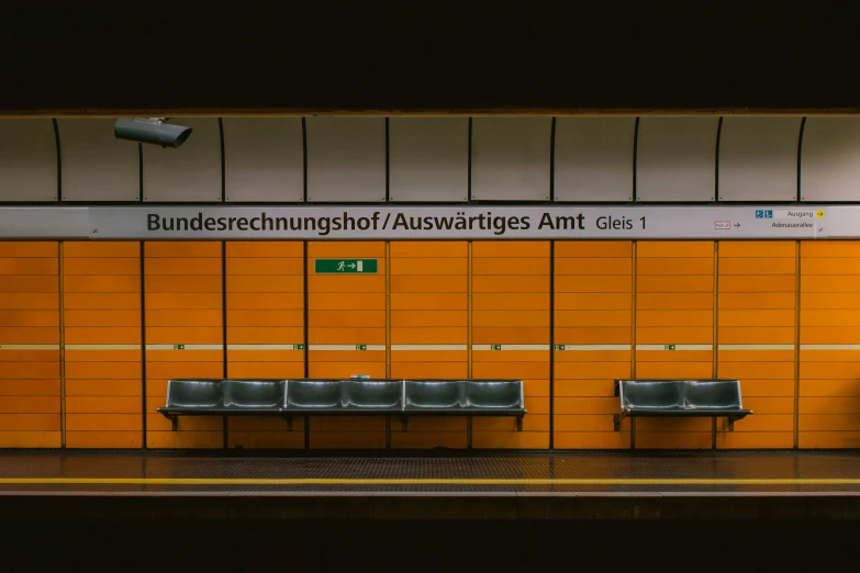 three silver bench in a public station with wooden boards