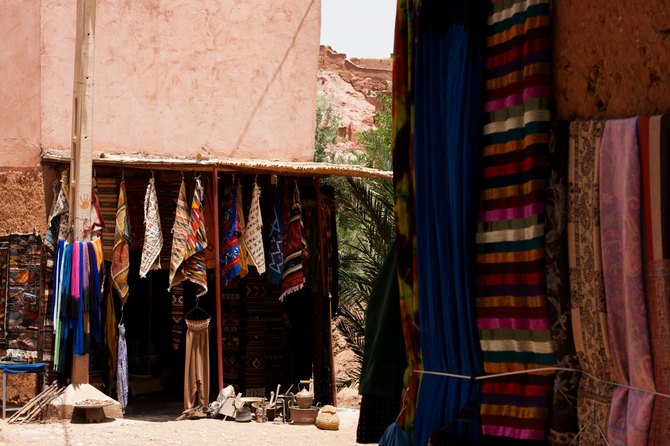 colorful items hanging out of the doorway of an adobe building