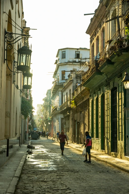 people are walking down an old street in front of buildings