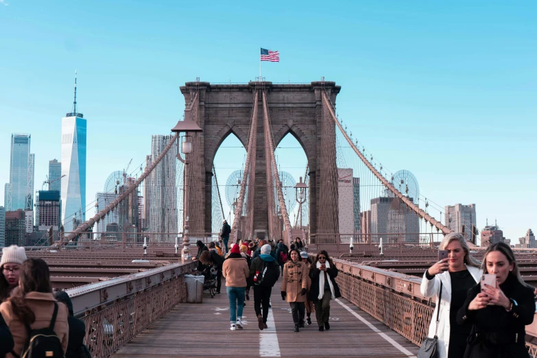 group of people walking across the brooklyn bridge