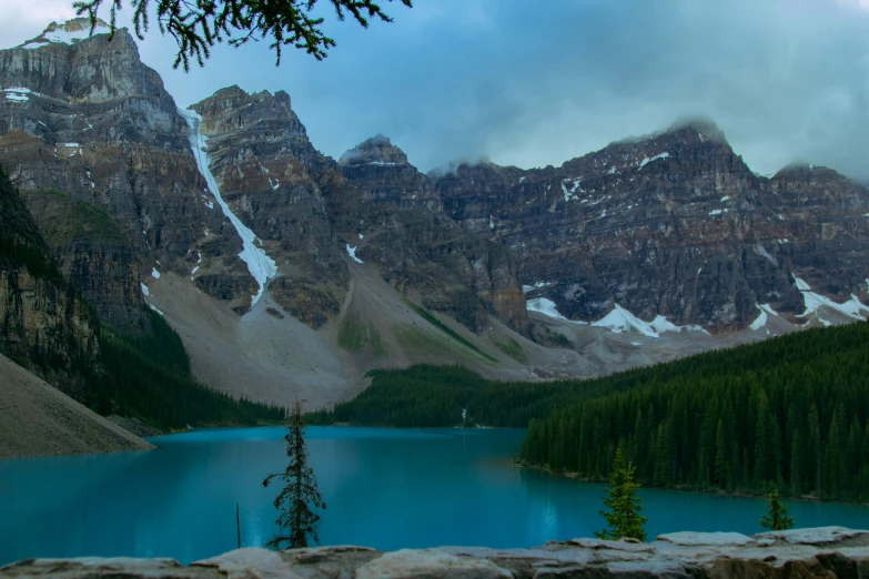 the mountains are shown in the distance behind a blue lake