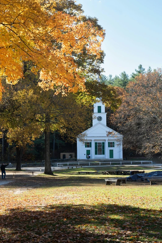 the church has red and yellow trees surrounding it