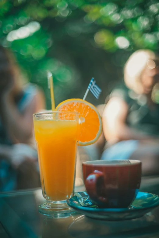 a drink on the table with people behind it