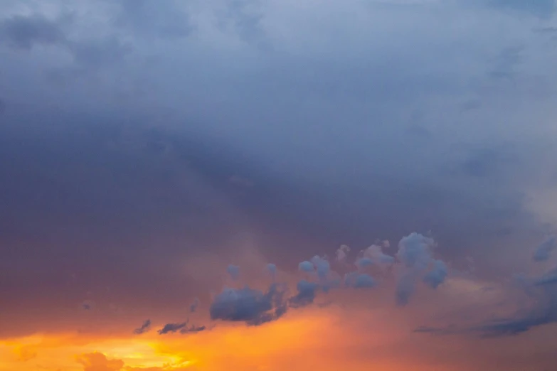 the sun sets behind a field with cattle