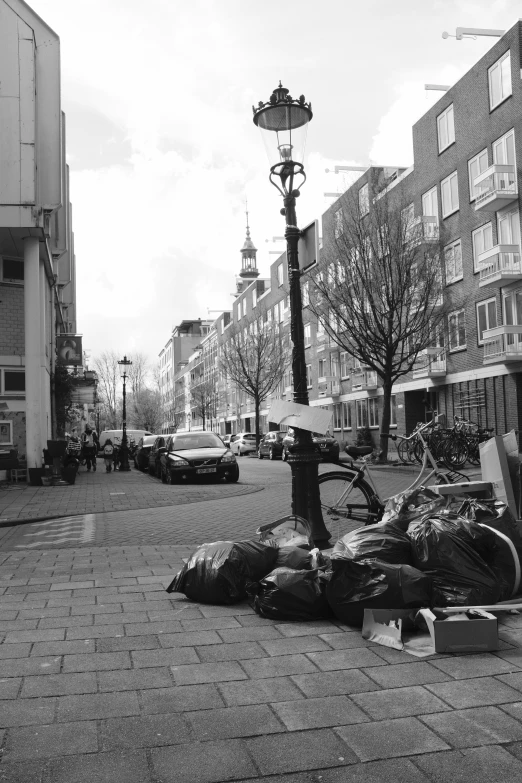 a bunch of bags sitting on the street next to the lamp