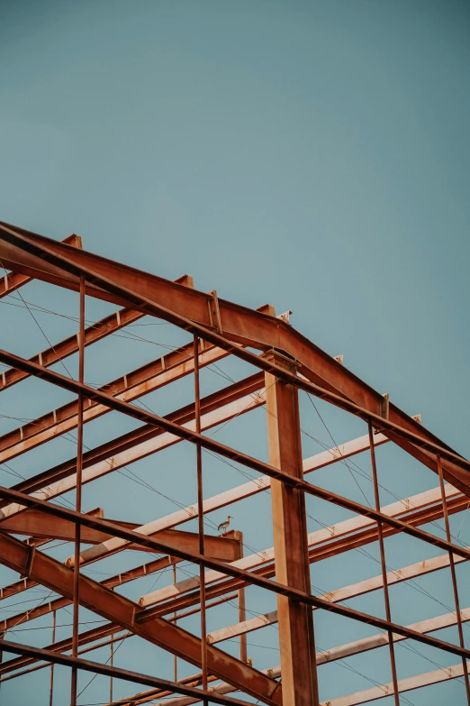 an airplane is flying over a building under construction