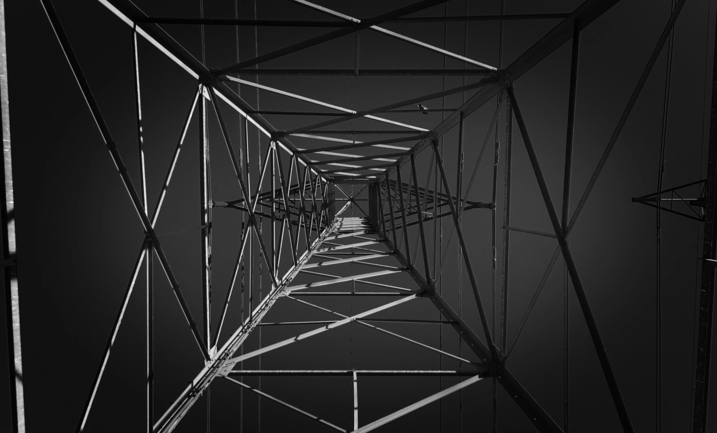 a large, dark metal tower structure with wires in it