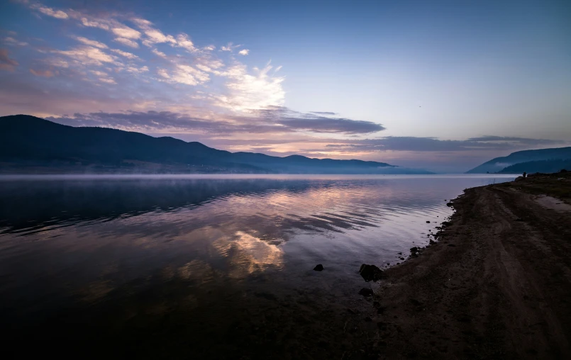 a large body of water sitting next to a mountain