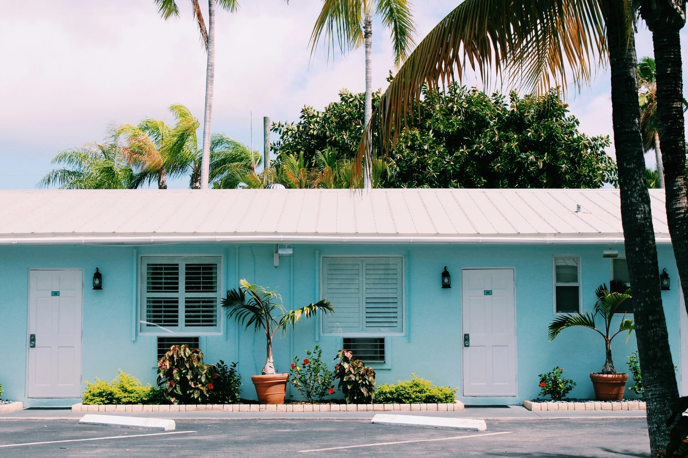 blue colored building with shuttered windows and a parking space