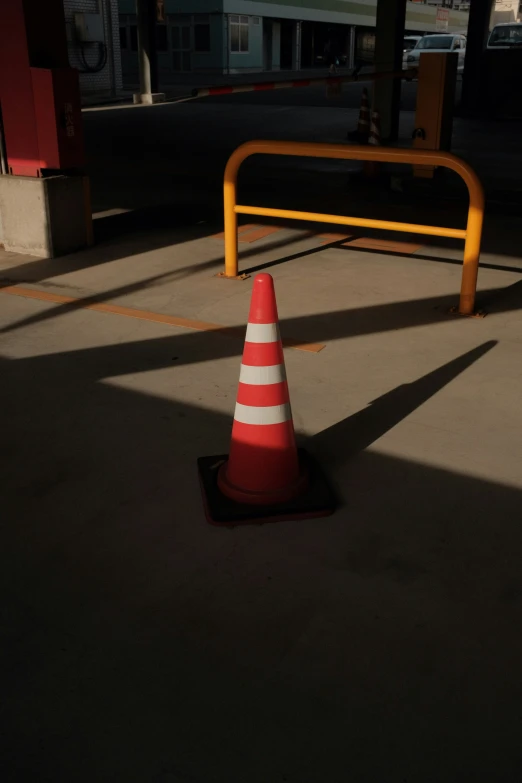 an orange traffic cone sits on a sidewalk