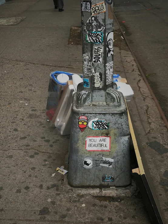 a graffiti covered parking meter on a sidewalk