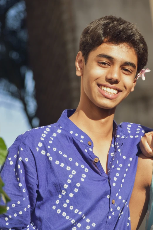 a young man in blue shirt holding a blue bag