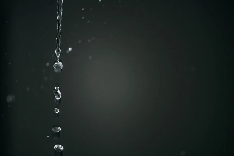 water droplets on black background and the droplet being released