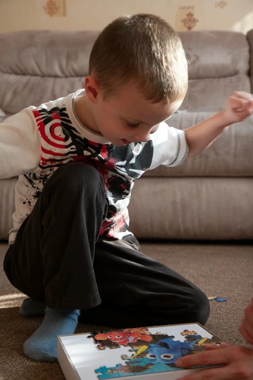 a small child sitting on the floor while playing with a game