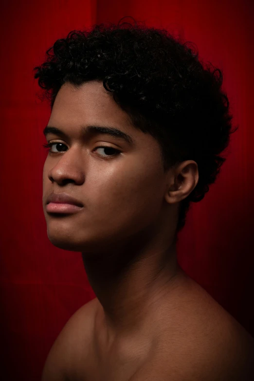 a shirtless man is looking back with a red background