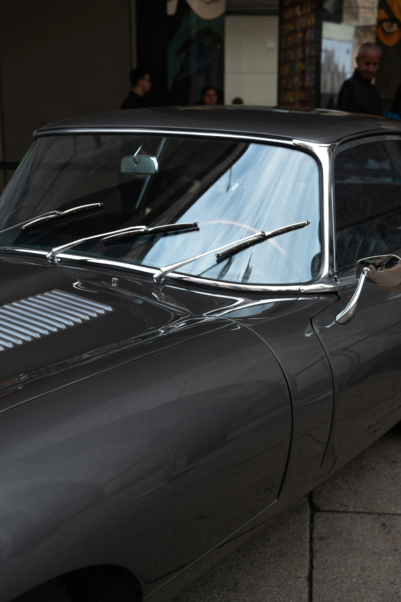 a grey classic car parked on the side of the road