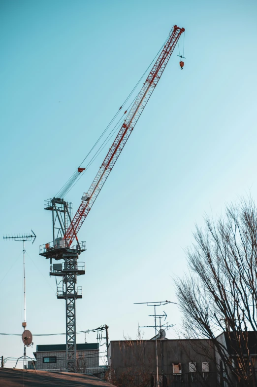 a red crane is standing in front of a building