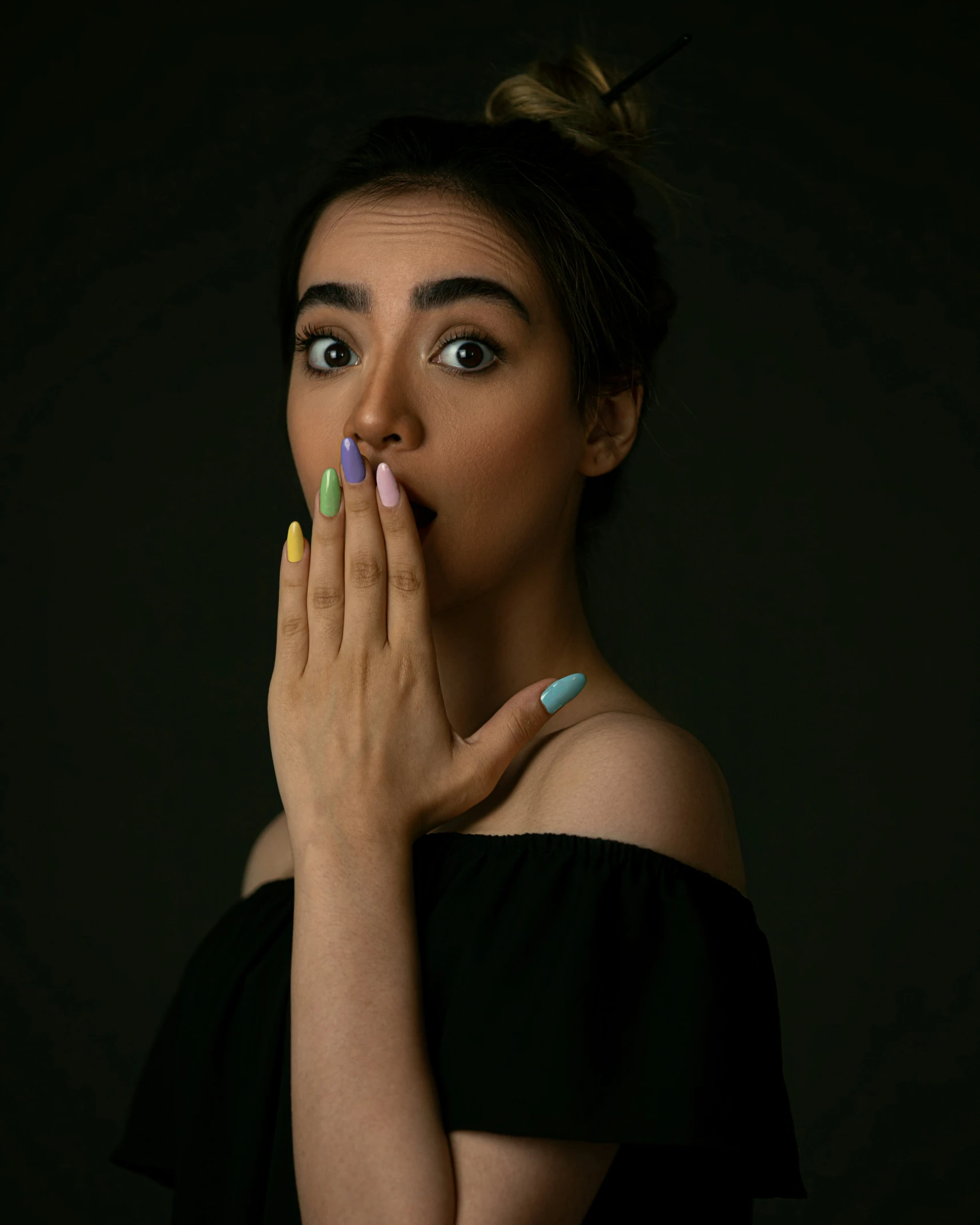 the woman in the black dress is posing with her hand on her mouth