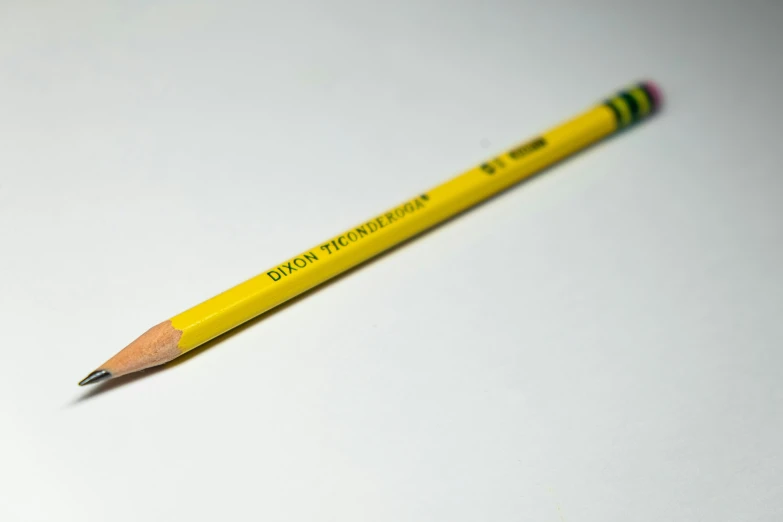 the pencil has yellow tips and is resting on a white surface