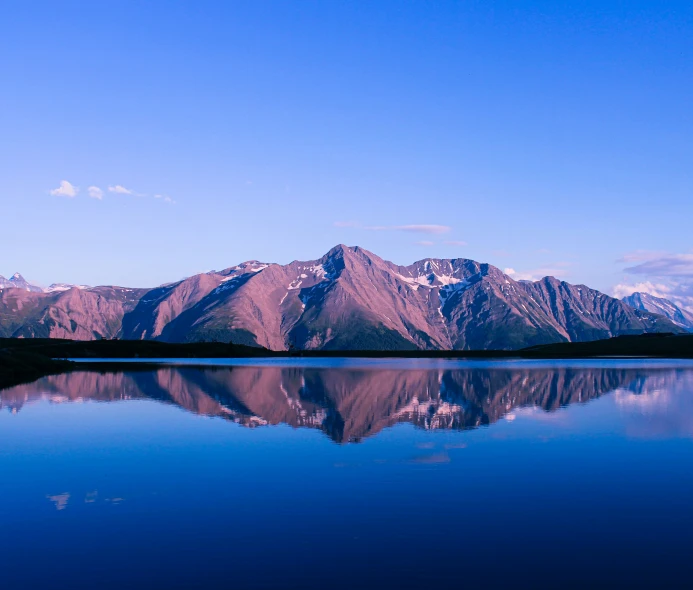 snow covered mountain ranges reflected in the calm lake