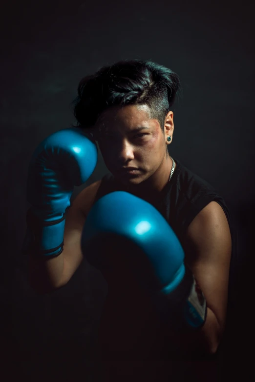 a young woman wearing blue boxing gloves