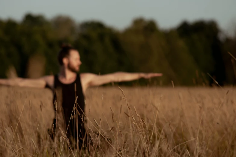 a person that is in the grass with their arms out