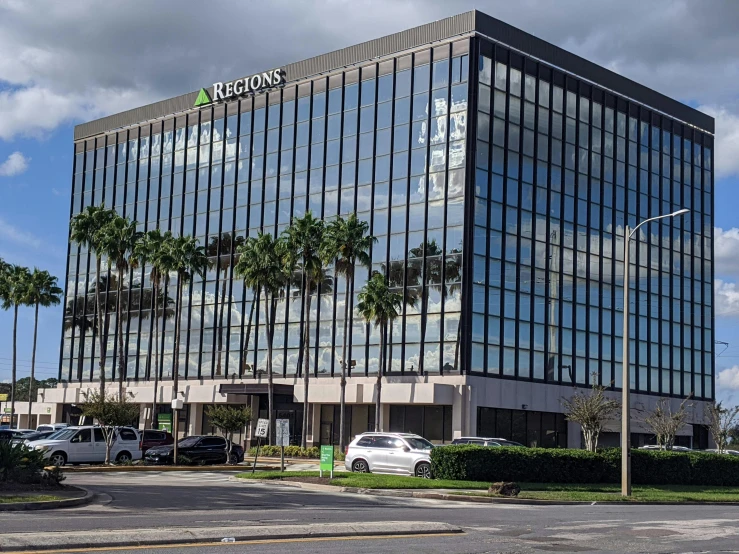 a building is on the corner with palm trees