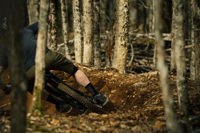 a man riding down a hill in the woods