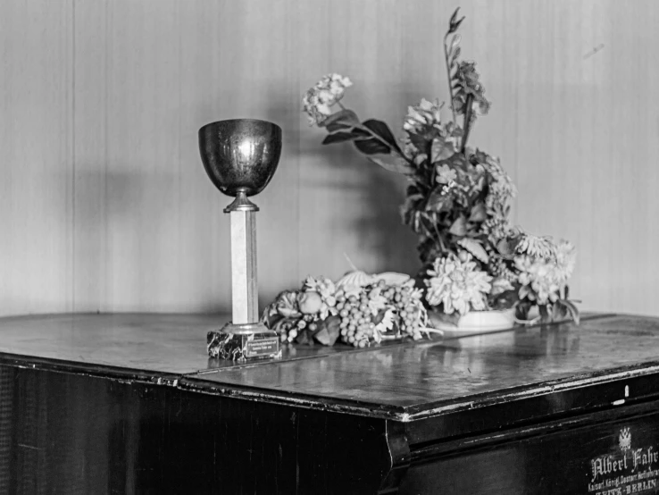 an antique desk has some flowers and a vase on it