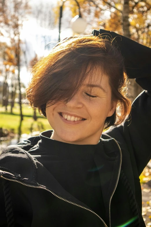 a woman smiles as she holds her hands up