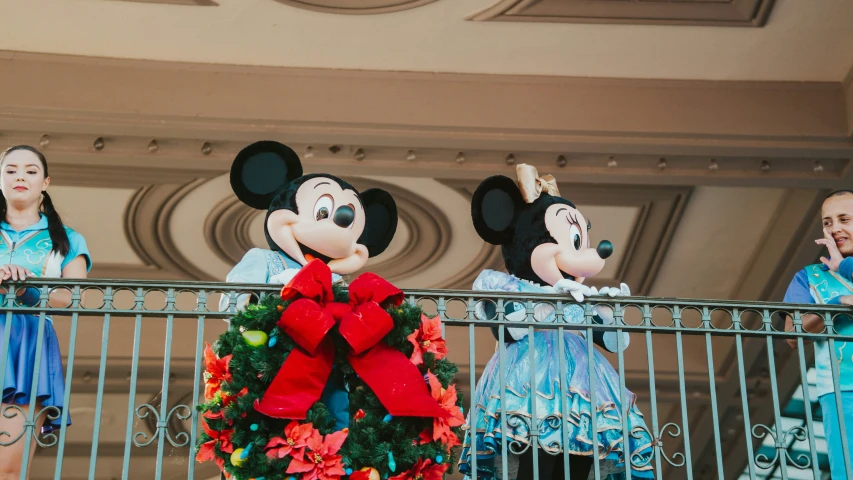 a mickey mouse character at the top of a balcony