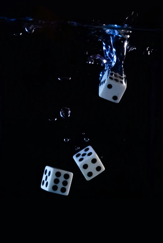 a black background with dices floating in water