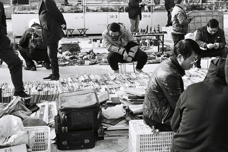 a group of people standing around a table covered with lots of food